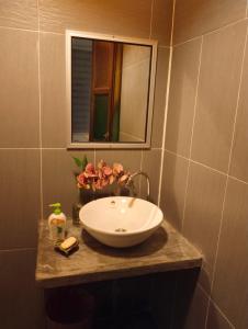 y baño con lavabo y espejo. en Pondok Keladi Langkawi Guesthouse, en Pantai Cenang