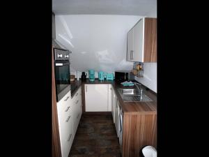 una pequeña cocina con electrodomésticos blancos y armarios de madera. en NEU Ferienwohnung Heda, en Dannewerk