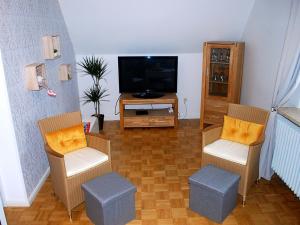 sala de estar con 2 sillas y TV en NEU Ferienwohnung Heda, en Dannewerk