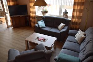 a living room with two couches and a coffee table at NEU Hafenhäuschen No 18 in Norden