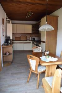 cocina con mesa de madera con sillas y comedor en NEU Hafenhäuschen No 18, en Norden