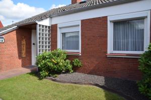 una casa de ladrillo rojo con ventana y patio en NEU Hafenhäuschen No 18, en Norden