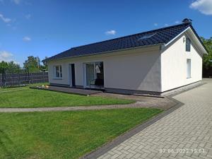 uma pequena casa branca com um relvado verde em NEU! Ferienhaus Römer em Bad Sülze