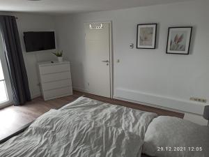 a bedroom with a bed and a dresser and a television at NEU! Ferienhaus Römer in Bad Sülze