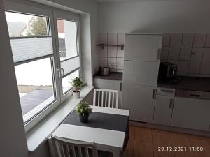 uma cozinha com uma mesa e um frigorífico branco em NEU! Ferienhaus Römer em Bad Sülze