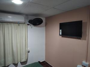 Una habitación con un televisor de pantalla plana en la pared. en Rinconada 736 Sustentable, en San Salvador de Jujuy