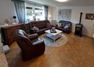 ein Wohnzimmer mit Ledersofas und einem Couchtisch in der Unterkunft NEU Ferienwohnung Lottje in Dannewerk