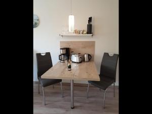 a wooden table with four chairs in a kitchen at NEU! Ferienwohnung Mien lütte Boe SPO in Sankt Peter-Ording