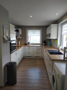 a large kitchen with white cabinets and a window at NEU Ferienwohnung Lottje in Dannewerk