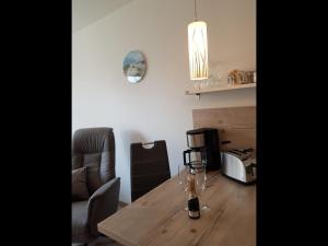 a dining room table with a bottle of wine on it at NEU! Ferienwohnung Mien lütte Boe SPO in Sankt Peter-Ording