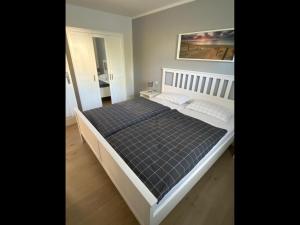 a bedroom with a bed with a black comforter at NEU! Moderne Ferienwohnung Almdorf in Almdorf