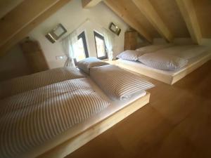 two white beds in a room with a attic at Die Schorenmoos-Lodge in Dietmannsried