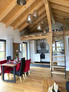 een woonkamer met een eettafel en een keuken bij Die Schorenmoos-Lodge in Dietmannsried