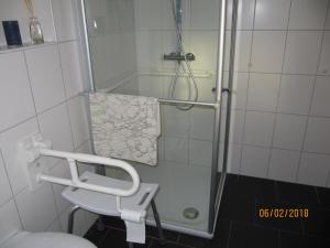 a bathroom with a shower with a sink and a toilet at Ferienhaus Fahrrinne 12 in Dornum +8 photos
