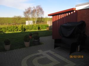 a red shed with a tarp on it next to a yard at Ferienhaus Fahrrinne 12 in Dornum