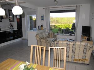 a living room with two couches and a kitchen at Ferienhaus Fahrrinne 12 in Dornum