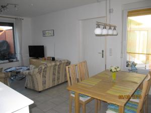 a living room with a table and a couch at Ferienhaus Fahrrinne 12 in Dornum