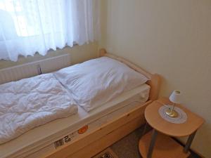 Dormitorio pequeño con cama y mesa en Fehaus Spiekeroog Wohnung 6, en Dornumersiel