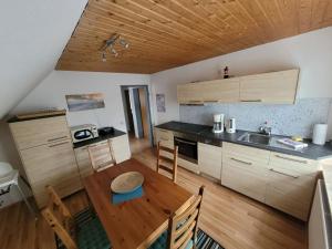 a kitchen with a wooden table and a wooden ceiling at NEU! Fewo Merle mit Balkon in Carolinensiel
