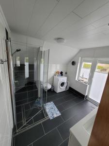 a bathroom with a shower and a toilet and a sink at NEU! Fewo Merle mit Balkon in Carolinensiel +11 photos