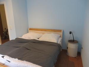 un lit dans une chambre avec une lampe à côté de celle-ci dans l'établissement FeWo Schwalbennest Dornumersiel, à Dornumersiel