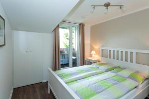 a white bedroom with a bed and a window at NEU! Ferienwohnung Zur Eiche in Toppenstedt