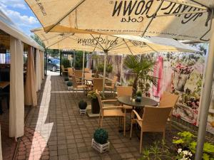 a patio with tables and chairs under umbrellas at LAS PALMAS ROOMS in Štúrovo