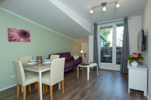 a living room with a table and a couch at NEU! Appartement Zur Heideblüte in Toppenstedt