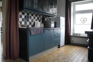 eine Küche mit einer blauen Theke und einem Fenster in der Unterkunft Ferienwohnung Geeske im Gulfhof in Krummhörn