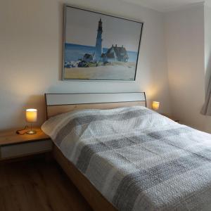 a bedroom with a bed and a picture of a lighthouse at Ferienwohnung Hafenkoje in Dornum
