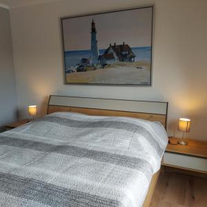 a bedroom with a bed and a picture of a lighthouse at Ferienwohnung Hafenkoje in Dornum