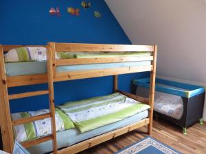 2 łóżka piętrowe w pokoju z niebieską ścianą w obiekcie NEU Nordseeferienhaus An der Mühle w mieście Westerholt