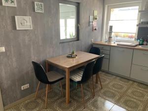 a kitchen with a wooden table and chairs at NEU! Ferienhaus Schliephake in Schöningen