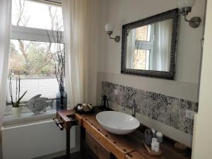baño con lavabo, espejo y ventana en NEU! Stilvolle FeWo Finsterwalde, en Finsterwalde