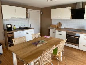 a kitchen with a wooden table and chairs at Ferienhaus Altenhof Müritz in Altenhof