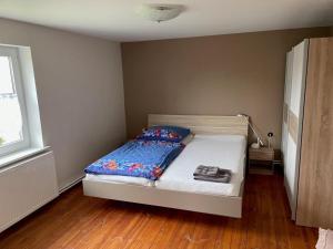 a bedroom with a bed in a room with wooden floors at Ferienhaus Altenhof Müritz in Altenhof