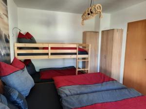 a bedroom with two bunk beds with red and blue pillows at NEU! Geschmackvolle FeWo Lengenfeld in Lengenfeld