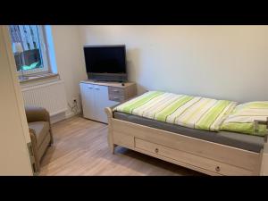 um quarto com uma cama e uma televisão de ecrã plano em NEU! Ferienwohnung MOIN em Langwedel