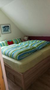 un letto con piumone a righe in una camera da letto di NEU! Galerie- Fewo mit Pool am Brombachsee a Theilenhofen