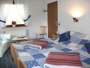 1 dormitorio con cama, mesa y ventana en NEU! Nordsee-Ferienhaus Lukas en Dornum