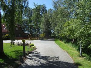 a driveway with trees and a house in the background at NEU! Nordsee-Ferienhaus Lukas in Dornum
