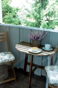 NEU! Appartement Zur Heidschnucke في Toppenstedt: طاولة صغيرة مع كعكة وزهرة على شرفة