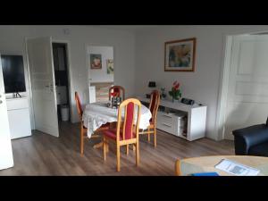 een woonkamer met een eettafel en stoelen bij NEU! Ferienwohnung Sylt in Taarstedt
