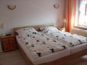a bed in a bedroom with a bedspread and pillows at NEU! Ferienwohnung Kruse EG in Norden