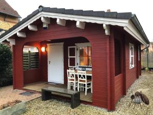 un cobertizo rojo con una mesa. en NEU! Ferienhütte Tiny House en Schöningen