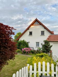 una casa bianca con una recinzione bianca davanti di NEU! Ferienwohnung Cottbus nähe Spreewald a Cottbus