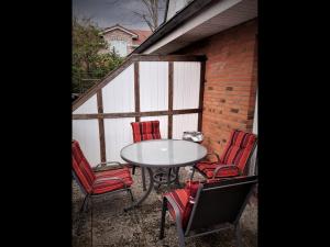 eine Terrasse mit einem Tisch und roten Stühlen in der Unterkunft NEU! Schicke Ferienwohnung Niebüll in Niebüll