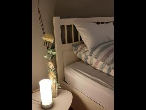 ein Bett mit einer Kerze und einer Vase auf dem Tisch in der Unterkunft NEU! Schicke Ferienwohnung Niebüll in Niebüll