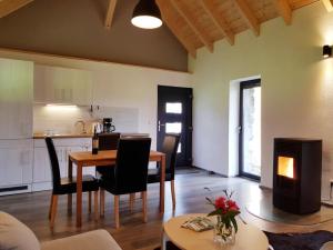 a living room with a table and chairs and a kitchen at NEU! Modernes Ferienhaus Hohensayn in Lautzenbrücken +15 photos