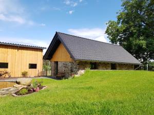 a barn with a grass yard in front of it at NEU! Modernes Ferienhaus Hohensayn in Lautzenbrücken